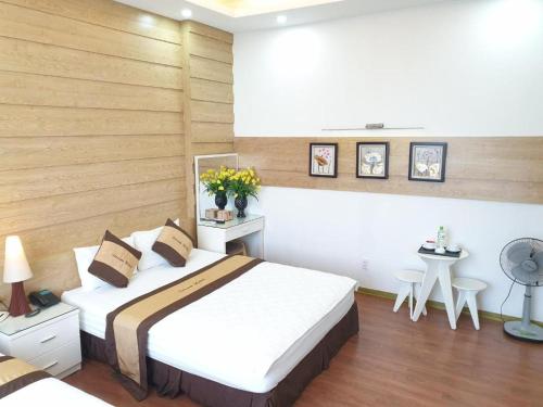 a bedroom with a bed and two tables with flowers at DREAM HOTEL Bắc Ninh in Hòa Ðình