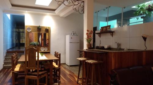 a kitchen and dining room with a table and a refrigerator at Recanto Alto da Glória in Diamantina