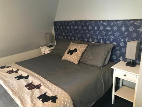 a bedroom with a bed with a blue patterned wall at Harbour bridge, Camps bar in Wick