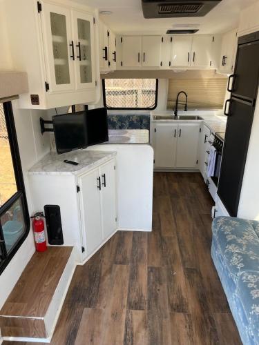 una cocina con armarios blancos y suelo de madera en RV2 Stunning RV Private Netflix FreeParking, en Moreno Valley