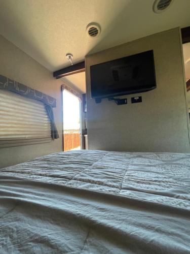 a bedroom with a bed with a tv on the wall at RV2 Stunning RV Private Netflix FreeParking in Moreno Valley