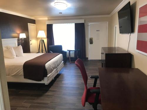 a hotel room with a bed and a table and chairs at Abby's Anaheimer Inn - Across Disneyland Park in Anaheim