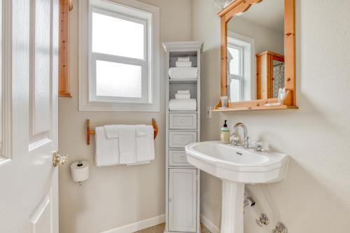 a white bathroom with a sink and a mirror at Piney Hideaway in White Salmon