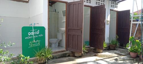 a bathroom with a toilet and a sign in front of it at Bami thakhek hostel in Thakhek