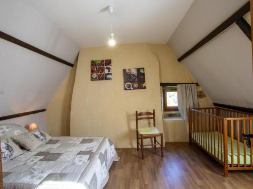 una camera da letto con un letto e una sedia in mansarda di Charmante maison périgourdine avec jardin, cheminée, Wifi et équipements bébé, proche de Sarlat - FR-1-616-130 a Saint-André-dʼAllas