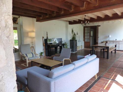 un salon avec un canapé et une table dans l'établissement Ferme rénovée avec charme, 4 chambres, grand jardin privé, cheminée, proche nature à Gouise ! - FR-1-489-374, à Gouise