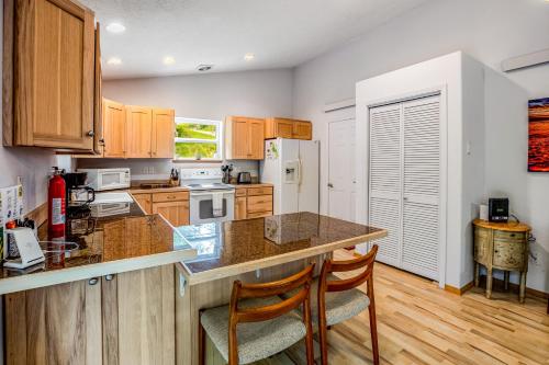a kitchen with wooden cabinets and a counter with chairs at Netarts Getaway in Tillamook