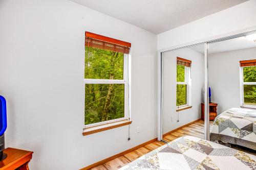 a bedroom with two beds and two windows at Netarts Getaway in Tillamook