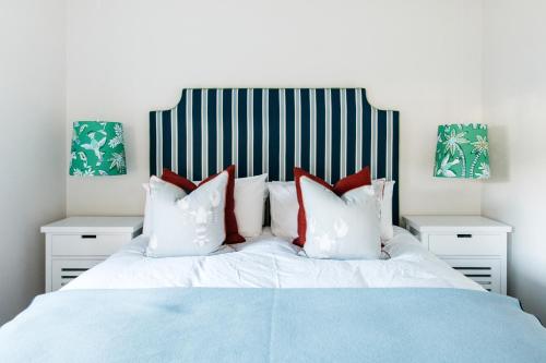 a bedroom with a bed with red and white pillows at The Patonga Cottage in Patonga Beach