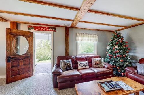 a living room with a christmas tree and a leather couch at Town Farm Retreat in Ludlow
