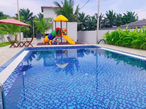 a swimming pool with a slide and a playground at Windmill Resort Private Place K.Selangor by Miko in Jeram