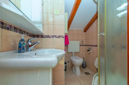 a bathroom with a sink and a toilet at Apartments Lucija in Korčula