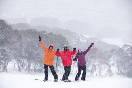 a group of three people on skis in the snow at Thredbo Alpine Hotel in Thredbo