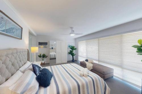 1 dormitorio con 1 cama grande y 1 sofá en “LA MAISON”, en Caboolture