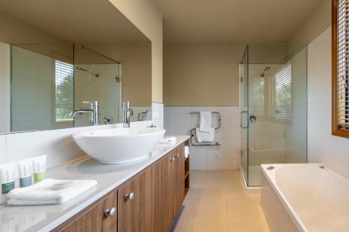 a bathroom with a large white sink and a tub at Wanaka Luxury Apartments in Wanaka