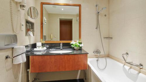 a bathroom with a sink and a tub and a mirror at InterContinental Budapest by IHG in Budapest