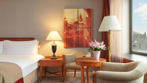 a hotel room with a bed and a desk and a bed and a window at InterContinental Budapest by IHG in Budapest