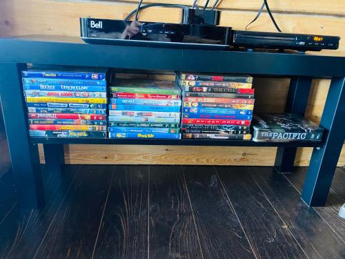 a pile of dvds sitting on a shelf at Artemis Log Cabin with Spa & Mountain View in Sainte-Lucie-de-Doncaster