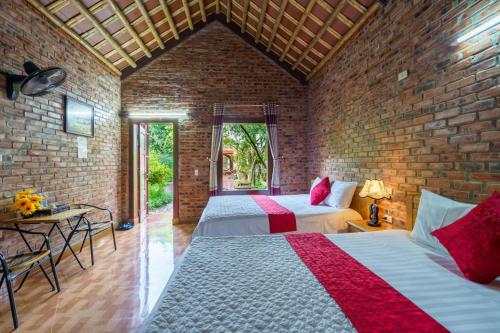 a bedroom with two beds and a brick wall at Tam Coc Mountain Lake Homestay in Ninh Binh