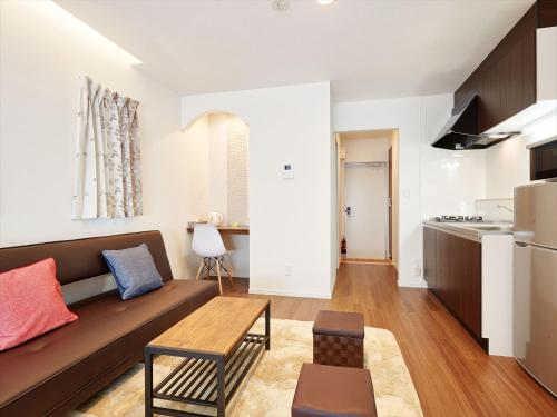 uma sala de estar com um sofá e uma cozinha em Condominium・yuyuki em Yomitan