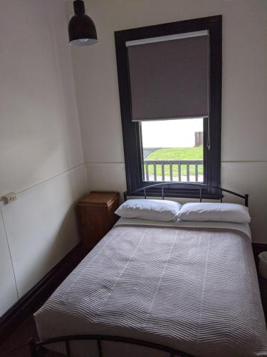 een slaapkamer met een bed en een raam met een blinde bij The Dorset Hotel in Derby