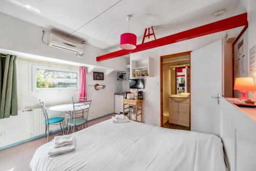 a bedroom with a white bed and a table at Studio sur Peniche, Le Cormoran, Bord De Saone A Lyon in Lyon