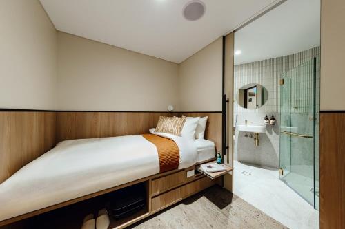 - une chambre avec un lit et une douche dans l'établissement Aerotel Sydney (Arrivals B, International Terminal 1), à Sydney