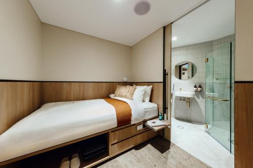 um quarto com uma cama e um chuveiro em Aerotel Sydney (Arrivals B, International Terminal 1) em Sydney