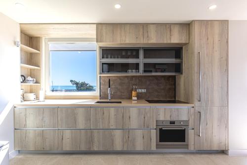 a kitchen with wooden cabinets and a window at Atico Puerto Sol in Altea