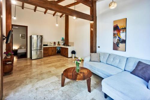 a living room with a blue couch and a table at Casas Santa Teresa in Santa Teresa Beach