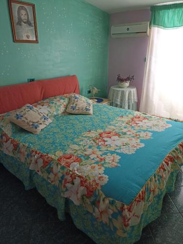 Una cama con una manta azul con flores. en Bed fiorella, en Acciaroli