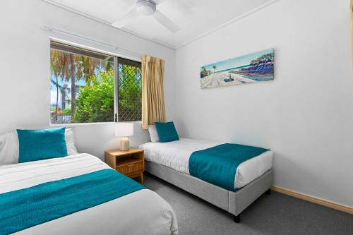 1 dormitorio con 2 camas y ventana en Ramada Encore by Wyndham Whale Cove, en Hervey Bay