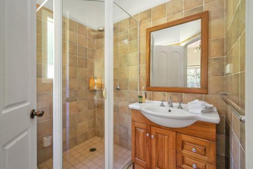 a bathroom with a sink and a mirror at Alcheringa Cottage Amazing Location with views in Kangaroo Valley