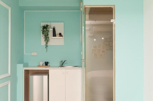 a bathroom with blue walls and a sink and a mirror at LJ Hotel in Kaohsiung