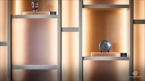 a pair ofjar doors with a vase and a trophy at Daiwa Roynet Hotel Kagoshima Tenmonkan PREMIER - former Daiwa Roynet Hotel Kagoshima Tenmonkan in Kagoshima