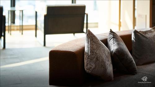 a brown couch with two pillows on it at Daiwa Roynet Hotel Kagoshima Tenmonkan PREMIER - former Daiwa Roynet Hotel Kagoshima Tenmonkan in Kagoshima