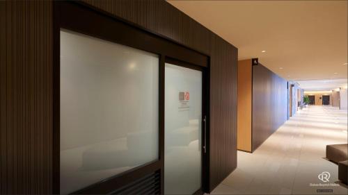a hallway with a glass door in a building at Daiwa Roynet Hotel Kagoshima Tenmonkan PREMIER - former Daiwa Roynet Hotel Kagoshima Tenmonkan in Kagoshima