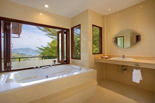 a large bathroom with a large tub and a window at Heavenly Villas in Patong Beach