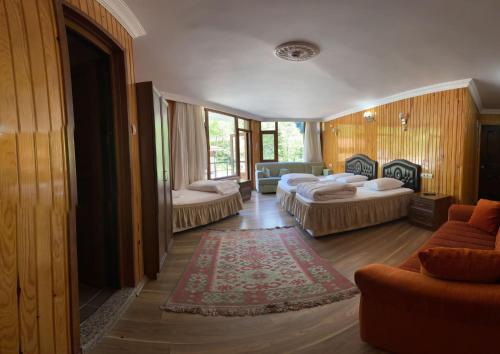 a living room with two beds and a couch at Yeşilvadi Otel in Ayder Yaylasi