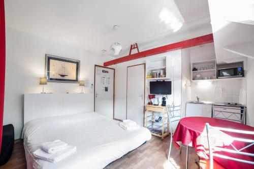 a small bedroom with a white bed and a table at Studio Peniche au coeur de Lyon pour 2 personnes, insolite et calme in Lyon