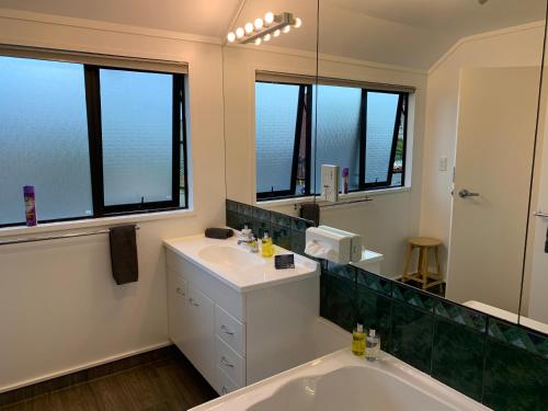 a bathroom with a tub and a sink and a mirror at 755 Regal Court Motel in Dunedin