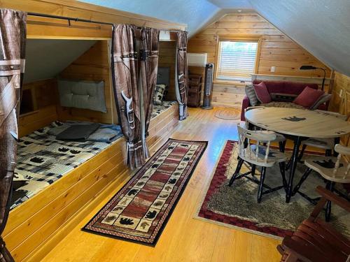 a living room with a table and a couch at Cubs Den - Hot Tub- Walk to Lake- Fire Pit - Kayaks in Oakland