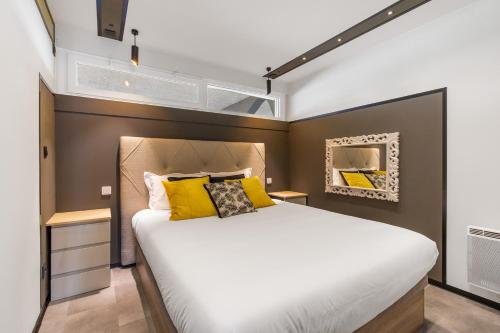 une chambre avec un grand lit avec des oreillers jaunes dans l'établissement Honey trap Port Ambonne naturiste, au Cap d'Agde