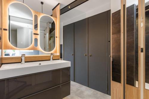 une salle de bain avec un lavabo et un miroir dans l'établissement Honey trap Port Ambonne naturiste, au Cap d'Agde