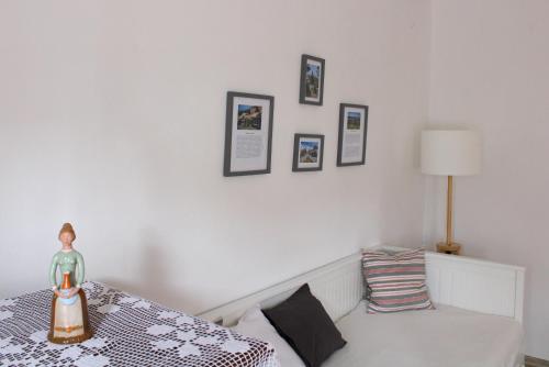 a bedroom with a bed with a lamp and pictures on the wall at Lankás Vendégház - Hollókő in Hollókő