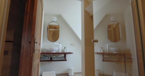 baño con 2 lavabos y 2 espejos en la pared en Berkies - autonome studio, en Steenokkerzeel