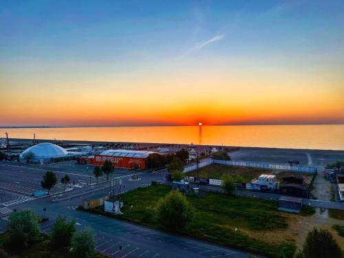 a sunset over a parking lot next to the water at Scoica Alba Mamaia Nord Summerland in Mamaia