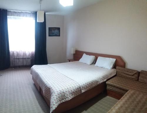 een hotelkamer met een bed en een raam bij Динара in Cholpon-Ata