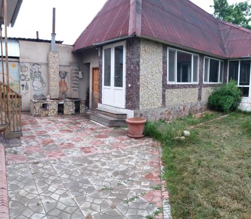 a house with a stone walkway in front of it at Динара in Cholpon-Ata