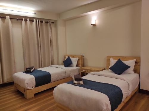 a room with two beds with blue pillows at Awale House in Pātan